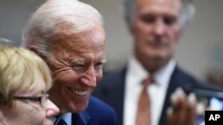 Former Vice President Joe Biden, a 2020 Democratic presidential candidate, poses for selfie photos with supporters after a campaign stop, July 6, 2019, in Sumter, S.C. 