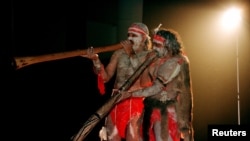 FILE - Two Aboriginal performers painted in traditional colors play the Didjiridoo aboriginal instrument at the launch of the Festival of the Dreaming in Sydney, July 22, 1997. 