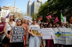 Protesters hold placards during a climate change rally in Sydney, Jan. 10, 2020.