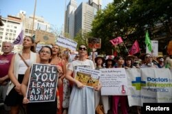 Protesters hold placards during a climate change rally in Sydney, Jan. 10, 2020.