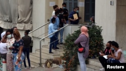 FILE - Ethiopian migrants wait to be helped outside the Ethiopian embassy in Beirut, July 16, 2020, during the COVID-19 pandemic. 