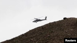 FILE - A U.S. Apache helicopter flies over Nangarhar province in April 2013. Iran said U.S. helicopters have been found transporting IS members from eastern Afghan to unknown locations.