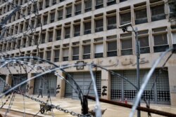 FILE - A worker walks outside the Lebanese Central Bank, March 18, 2020.