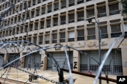 FILE - A worker walks outside the Lebanese Central Bank, March 18, 2020.