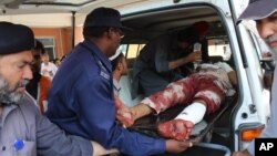 FILE - Pakistani volunteers carry an injured person who arrived from Mardan, at a local hospital in Peshawar, Pakistan, Sept. 2, 2016.