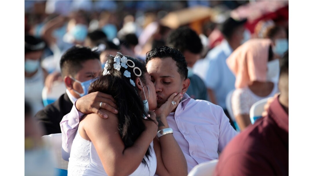 Una pareja se besa durante una boda masiva en Managua, Nicaragua, el domingo 14 de febrero de 2021.