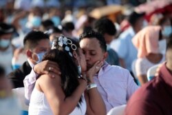 Una pareja se besa durante una boda masiva en Managua, Nicaragua, el domingo 14 de febrero de 2021.
