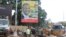 FILE - People pass in front of an electoral campaign poster for incumbent President Alpha Conde in Conakry, Guinea, Sept. 10, 2015. 