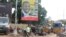 People pass in front of an electoral campaign poster for incumbent President Alpha Conde in Conakry, Guinea, Sept. 10, 2015. 