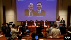 Thomas Perlmann, le secrétaire du Comité Nobel, à côté d'un écran affichant les lauréats du Prix Nobel de physiologie ou médecine 2021 David Julius (L) et Arden Patapoutian, lors d'une conférence de presse à l'Institut Karolinska de Stockholm, Suède, le 4