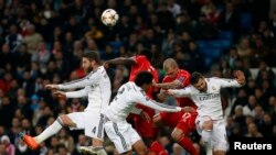 Liverpool and Real Madrid players jump for a ball during their Champions League Group B soccer match in Madrid November 4, 2014. 