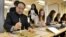 Mo Yan, Chinese winner of the 2012 Nobel Prize in Literature, demonstrates Chinese calligraphy to a student during a visit to a high school in Lidingo, outside Stockholm, Dec. 7, 2012. 
