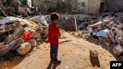 Seorang bocah laki-laki berdiri di depan reruntuhan bangunan yang dihantam oleh serangan Israel di Rafah, di bagian selatan Jalur Gaza pada 8 Mei 2024. (Foto: AFP)