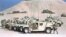 FILE - U.S. Marines tend to a row of parked humvees with TOW anti-tank missile launchers mounted on them at a desert camp in Saudi Arabia during the Gulf War, Jan. 26, 1991. 