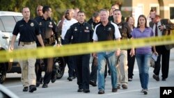 Walikota Orlando Buddy Dyer, tengah kanan, dan Kepala Polisi Orlando John Mina, tengah kiri, tiba di konferensi pers setelah penembakan fatal di sebuah klub malam di Orlando, Florida, 12 Juni 2016. 