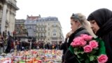 People observe a minute of silence at a street memorial to victims of Tuesdays's bombings in Brussels, Belgium, March 24, 2016. 