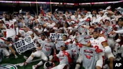 FILE - Members of the Miami of Ohio team pose on the field after the Mid-American Conference championship NCAA college football game against Central Michigan, in Detroit, Michigan, Dec. 7, 2019.