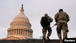 National Guard members walk at the Capitol,