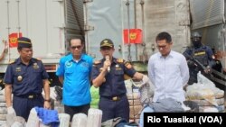 Dirjen Bea Cukai Heru Pambudi (kedua kanan) menunjukkan pakaian yang diselundupkan di Kantor Pusat Bea Cukai, Rabu, 11 Maret 2020. Total selundupan pakaian senilai Rp 2,6 miliar. (Foto: Rio Tuasikal/VOA)