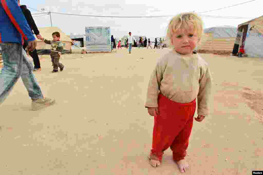 A Syrian boy stands in front of his family's tent at Al-Zaatri refugee camp in the Jordanian city of Mafraq, near the border with Syria, January 25, 2013.