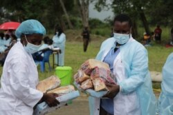 Medical workers distribute food to returnees at the quaratine facility in Blantyre, Jan. 11, 2021. (Lameck Masina/VOA)