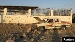 FILE - A car sits next to a salvage yard hit by a Houthi rocket in an industrial area in eastern Najran city, Saudi Arabia, Aug. 27, 2016. 