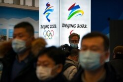 Para pengunjung mengenakan masker saat menyaksikan pameran di lokasi penyelenggaraan Olimpiade Musim Dingin di Yanqing, di pinggiran Beijing, 5 Februari 2021. (Foto: dok)