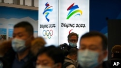 Para pengunjung lokasi penyelenggaraan Olimpiade Musim Dingin mengenakan masker untuk mencegah infeksi virus corona, di Yanqing, pinggiran Kota Beijing, China, 5 Februari 2021. 