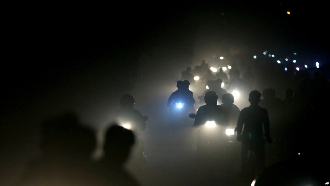 Pengendara motor di India melaju di tengah kabut asap dan debu tebal di pinggiran New Delhi, India, 10 November 2017. 