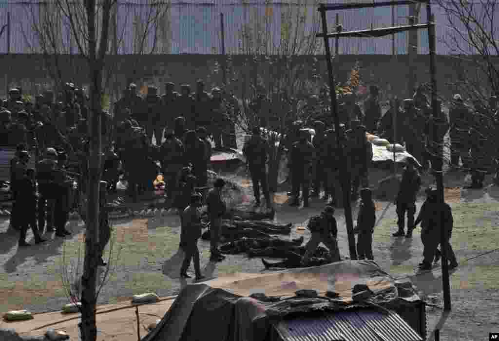 Indian army soldiers stand near bodies of suspected militants killed in a gunbattle in Gingal, Friday, Dec. 5, 2014.