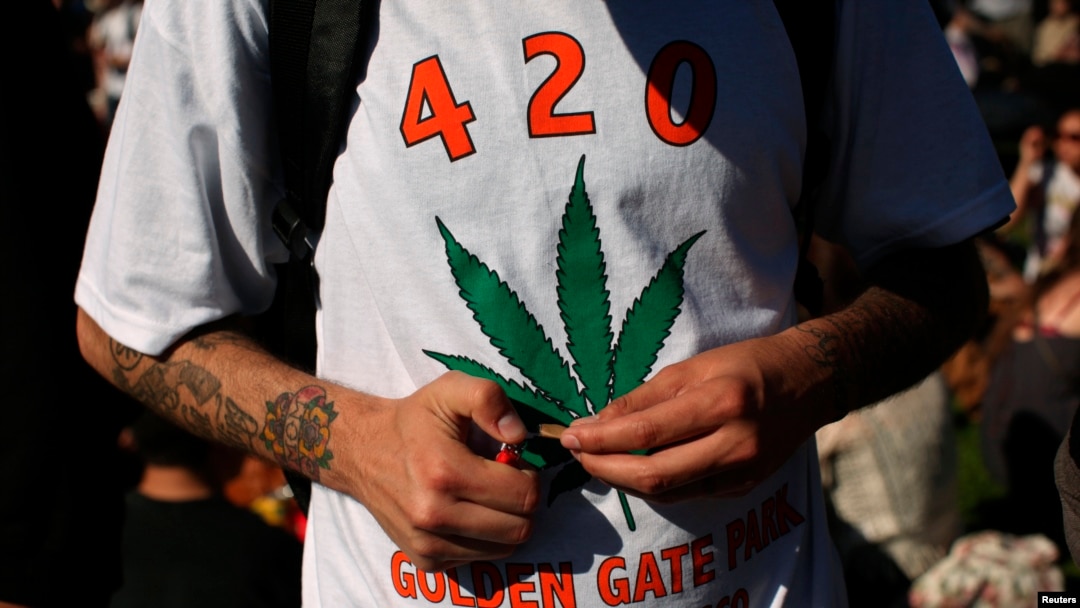 FILE - A man holds a joint during a gathering of marijuana advocates at Golden Gate Park in San Francisco, California.