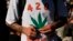 FILE - A man holds a joint during a gathering of marijuana advocates at Golden Gate Park in San Francisco, California.