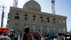 FILE - This frame grab image from video, shows a Taliban fighter standing guard outside the site of a bomb explosion inside a mosque, in Mazar-e-Sharif province, Afghanistan, April 21, 2022.