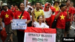 FILE - Anti-corruption activist Le Hien Duc (C) is assisted by anti-China protesters as they march during a protest along a street in Hanoi.