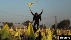 Syrian Kurds hold flags as they gather in Hasakah, Syria, after Turkey's jailed militant leader Abdullah Ocalan called on his Kurdistan Workers' Party to lay down its arms, Feb. 27, 2025.