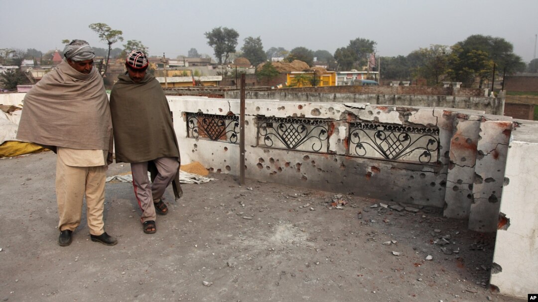 Indian villagers inspect the damage on the roof of a house, caused allegedly by firing from the Pakistan side of the border at Bainglad village in Samba sector, about 52 Kilometers from Jammu, India, Jan. 3, 2015.