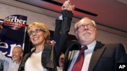 In an election to fill former Rep. Gabrielle Giffords, left, D-Ariz., congressional seat, Democratic candidate Ron Barber, right, celebrates a victory with Giffords and supporters at a post election event, in Tucson, Ariz, June 12, 2012 .