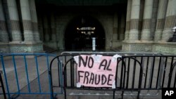 Un cartel cuelga de una barrera en el Palacio Nacional durante una protesta contra la candidata presidencial Zury Ríos Sosa, hija del difunto dictador de Guatemala Efraín Ríos Montt, en Ciudad de Guatemala, el 23 de marzo de 2023. 