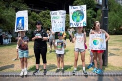 Demonstrators hold up placards during a climate protest rally in Sydney, Austalia, Dec. 21, 2019.
