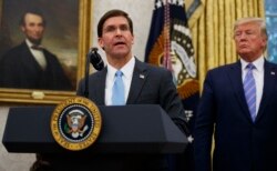 FILE - President Donald Trump looks on as Secretary of Defense Mark Esper speaks in the Oval Office at the White House in Washington, July 23, 2019.