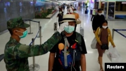 A passenger has his temperature checked due to the coronavirus outbreak as he arrives at Phuket airport, Thailand March 9, 2020. REUTERS/Soe Zeya Tun - RC2JGF9N67ZG