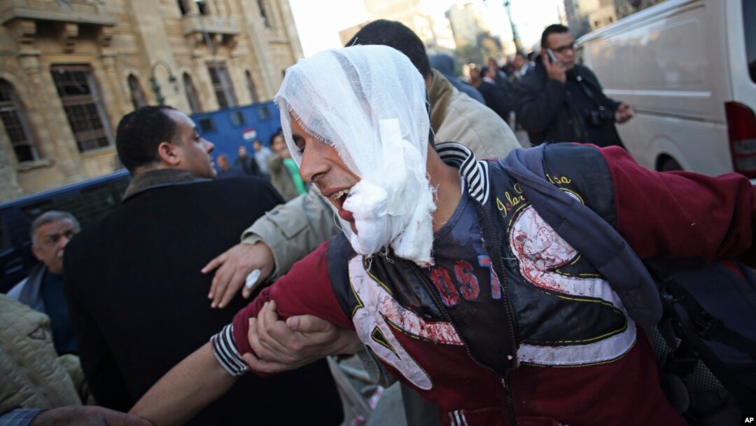Un hombre herido es llevado a una ambulancia luego de un atentado en contra del cuartel de la policía en el centro de El Cairo. Cuatro bombas han estallado este viernes provando la muerte de seis personas.