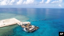 In this photo provided by the Department of National Defense, ships carrying construction materials are docked at the new beach ramp at the Philippine-claimed island of Pag-asa in the South China Sea on June 9, 2020.