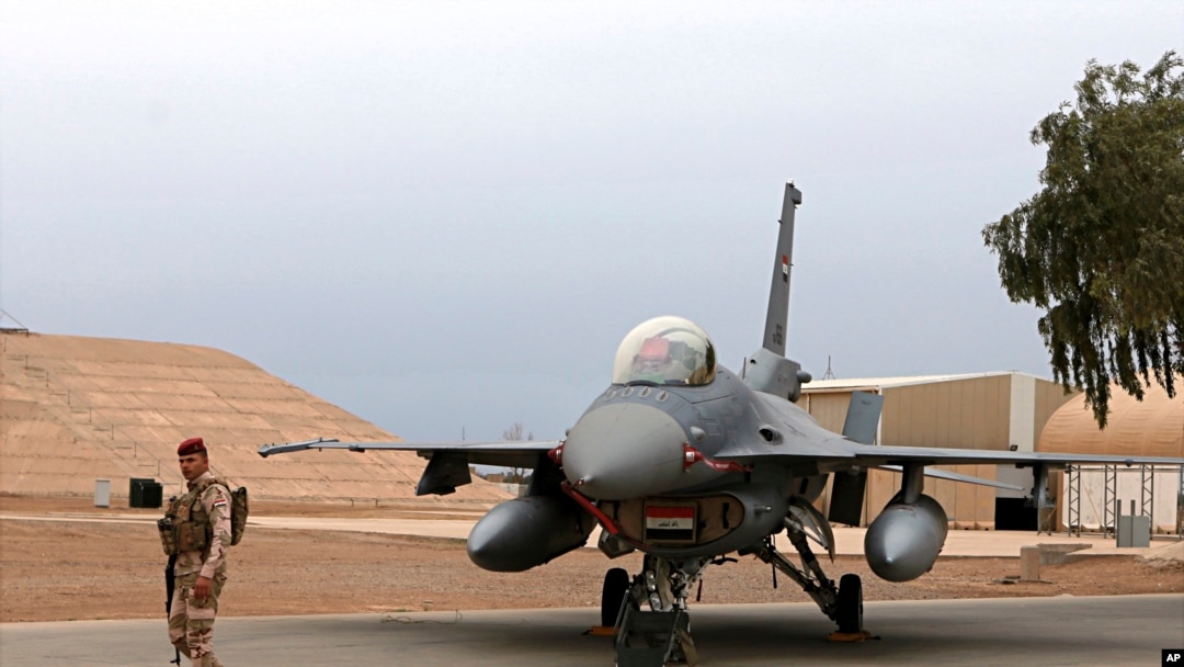 FILE - An Iraqi army soldier stand guard near a U.S.-made Iraqi Air Force F-16 fighter jet, at Balad Airbase, Iraq, Feb. 13, 2018.