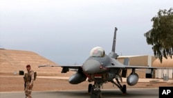 Umusirikare wa Iraki ahagaze hafi y'indege ya Amerika, F-16, kw'ikambi ya Balad Air muri Iraki, kw'itariki 13/02/2018.