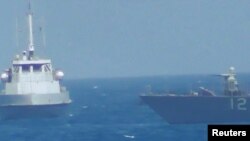 Sebuah kapal Iran tampak berada pada posisi terlalu dekat dengan kapal perang AS USS Thunderbolt (kanan) di perairan Teluk Persia, Selasa (25/7). 