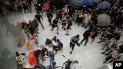 Policemen scuffle with protesters inside a shopping mall in Sha Tin District in Hong Kong, July 14, 2019. 