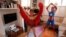 Dressed as superheroes, Jo Proudlove and daughter Eve, 9, follow the daily online "PE with Joe" Joe Wickes' exercise class on "Fancy dress Friday," at home in London, as the spread of the coronavirus disease (COVID-19) continues.