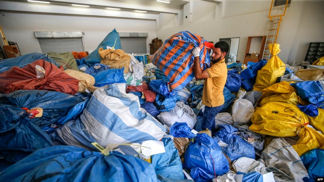 A Palestinian postal worker sifts through sacks of previously undelivered mail dating as far back as 2010, which has been withheld by Israel, at the central international exchange post office in the West Bank city of Jericho on Aug. 14, 2018.