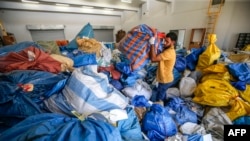 A Palestinian postal worker sifts through sacks of previously undelivered mail dating as far back as 2010, which has been withheld by Israel, at the central international exchange post office in the West Bank city of Jericho on Aug. 14, 2018.